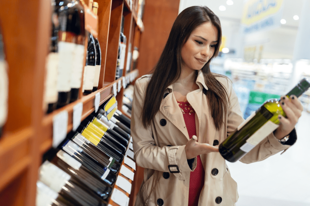 Woman looking at bottle of wine